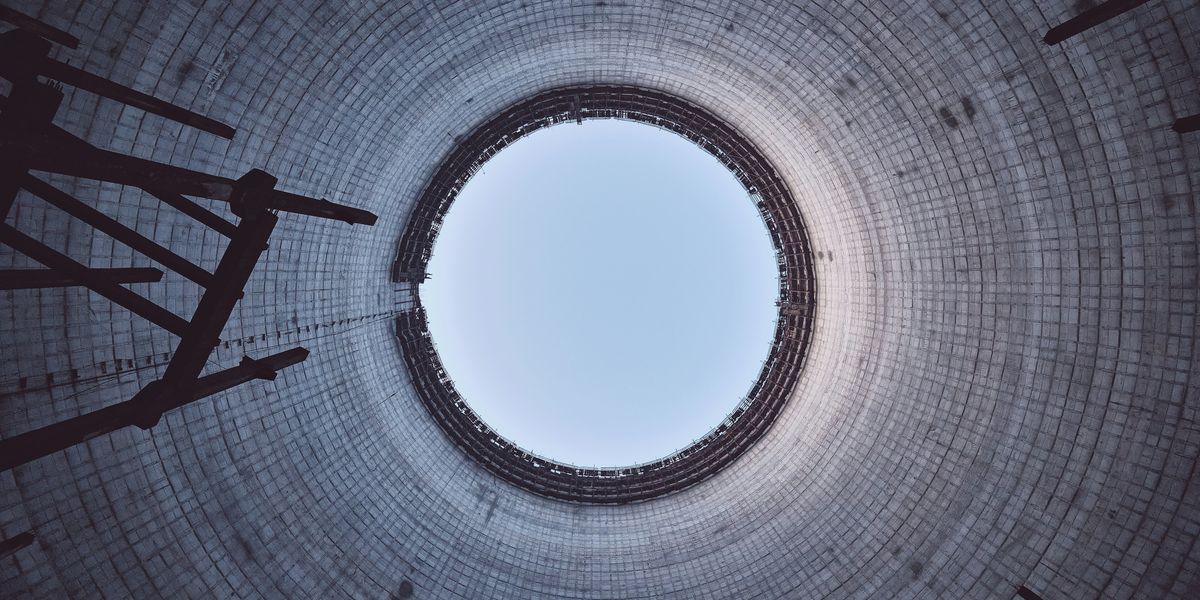 A view of a nuclear tower looking up through the top opening.