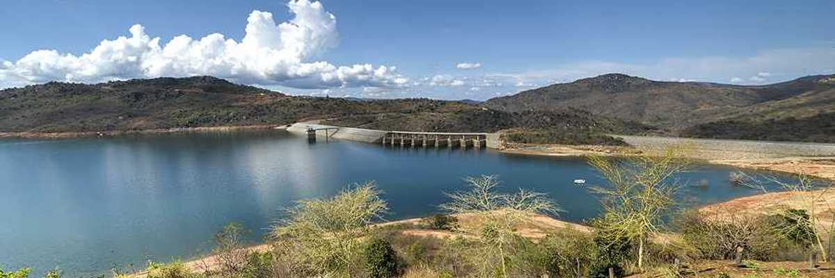 A view of a reservoir and dam with dry land surrounding it