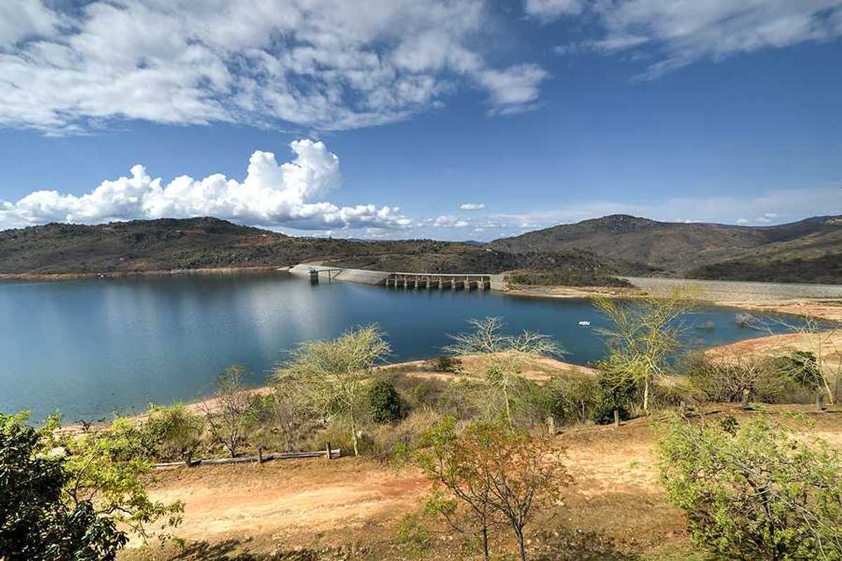 A view of a reservoir and dam with dry land surrounding it