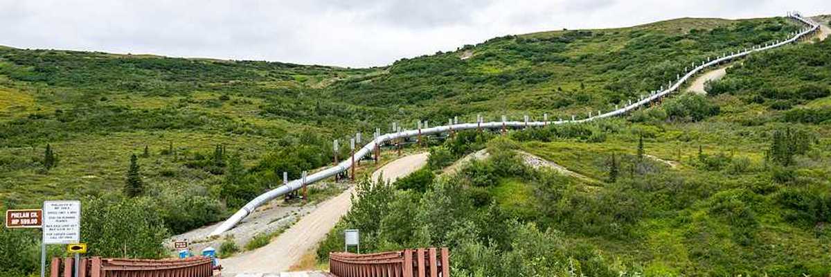 A view of a road in Alaska with an oil pipeline alongside it