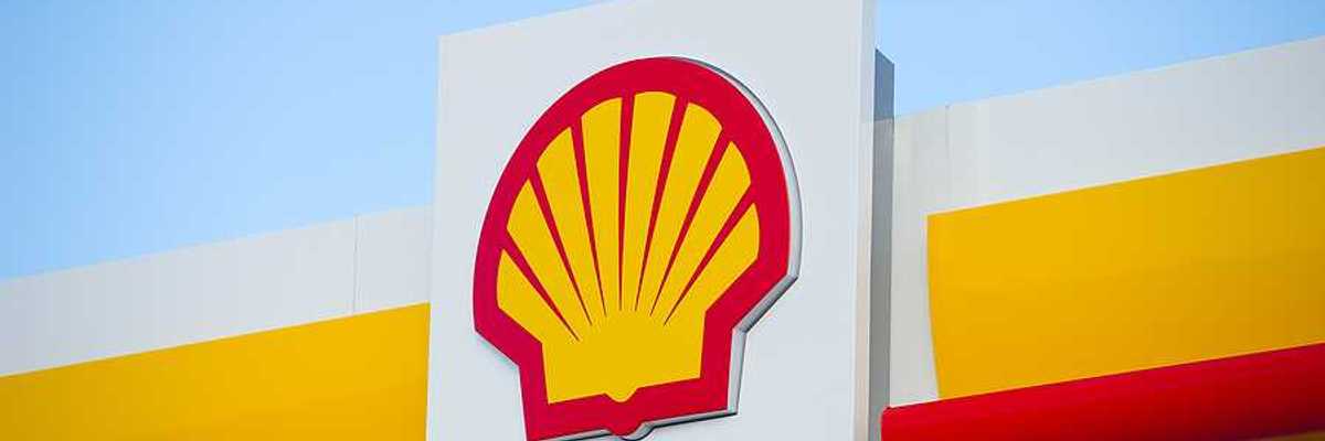 A view of a sign with the Shell Oil logo on it in red and yellow in the shape of a shell