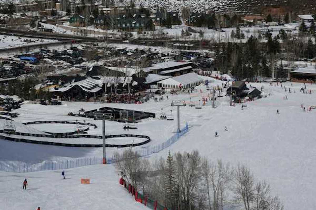 A view of a ski resort with people skiing down a hill