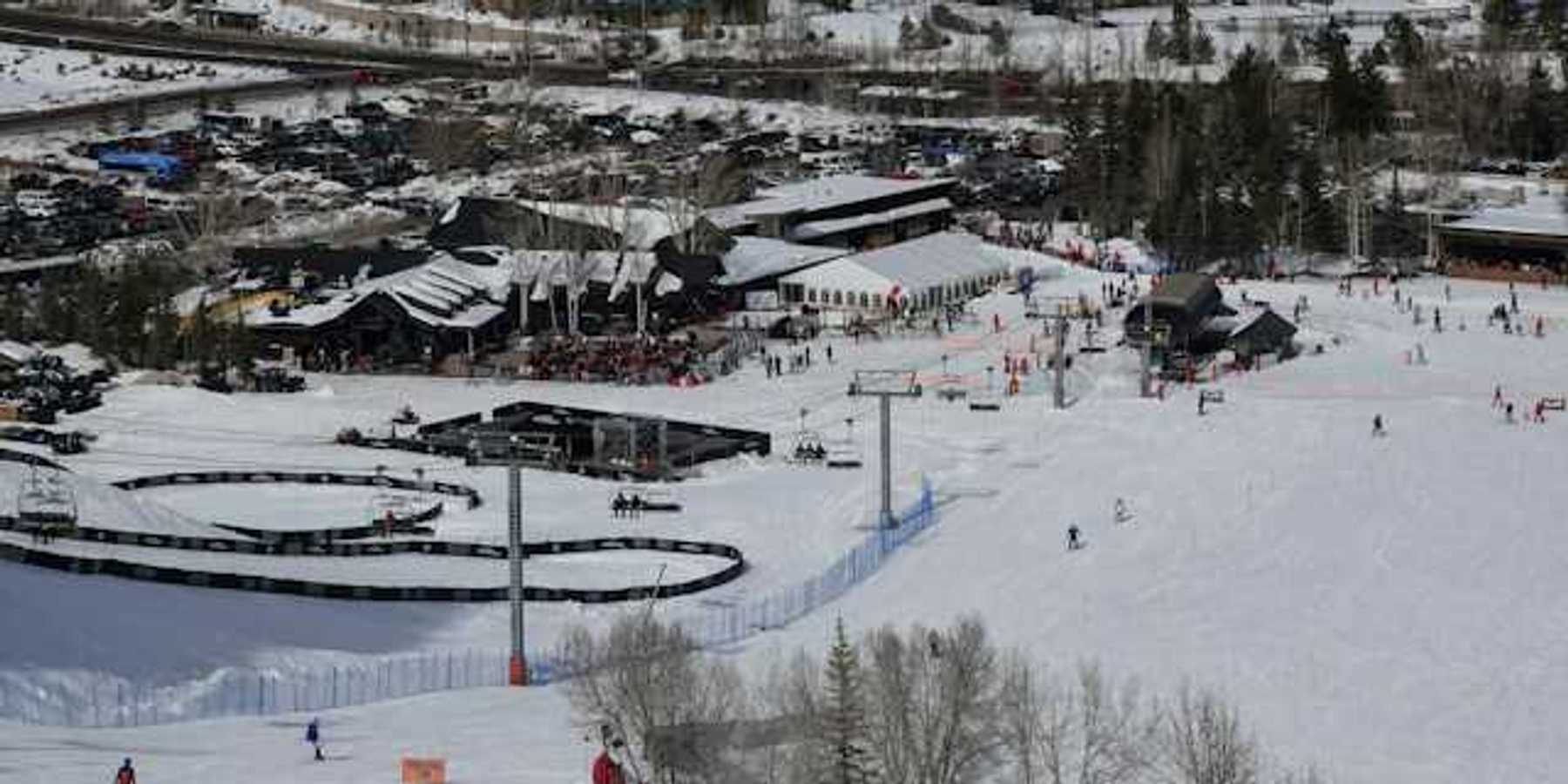 A view of a ski resort with people skiing down a hill