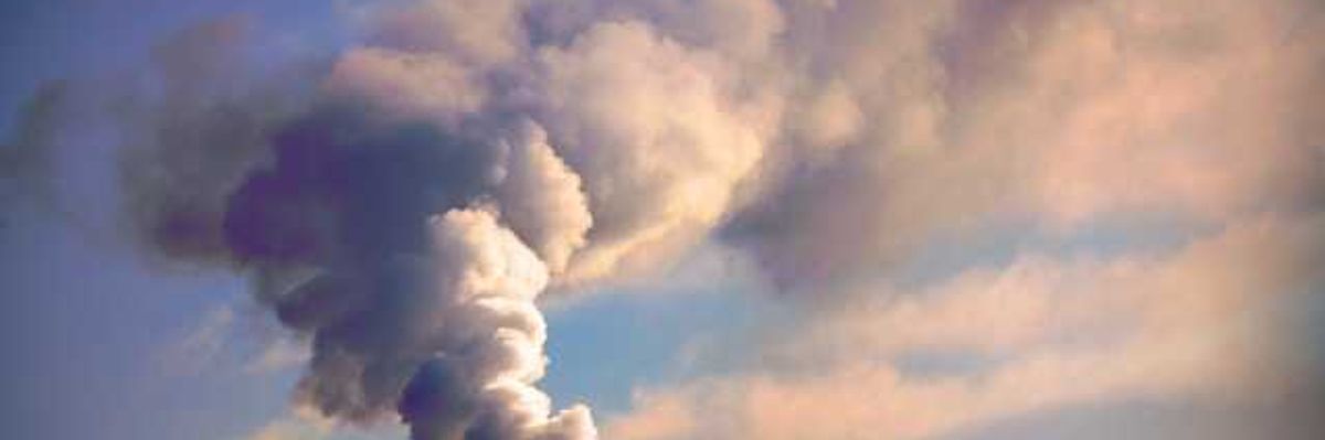 A view of a smokestack with billowing smoke