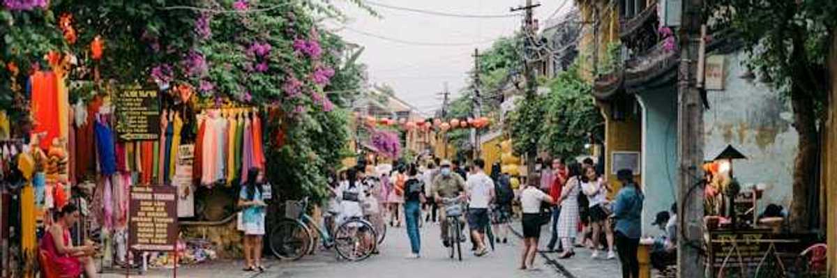 A view of a street with lots of flowering vines growing on the houses