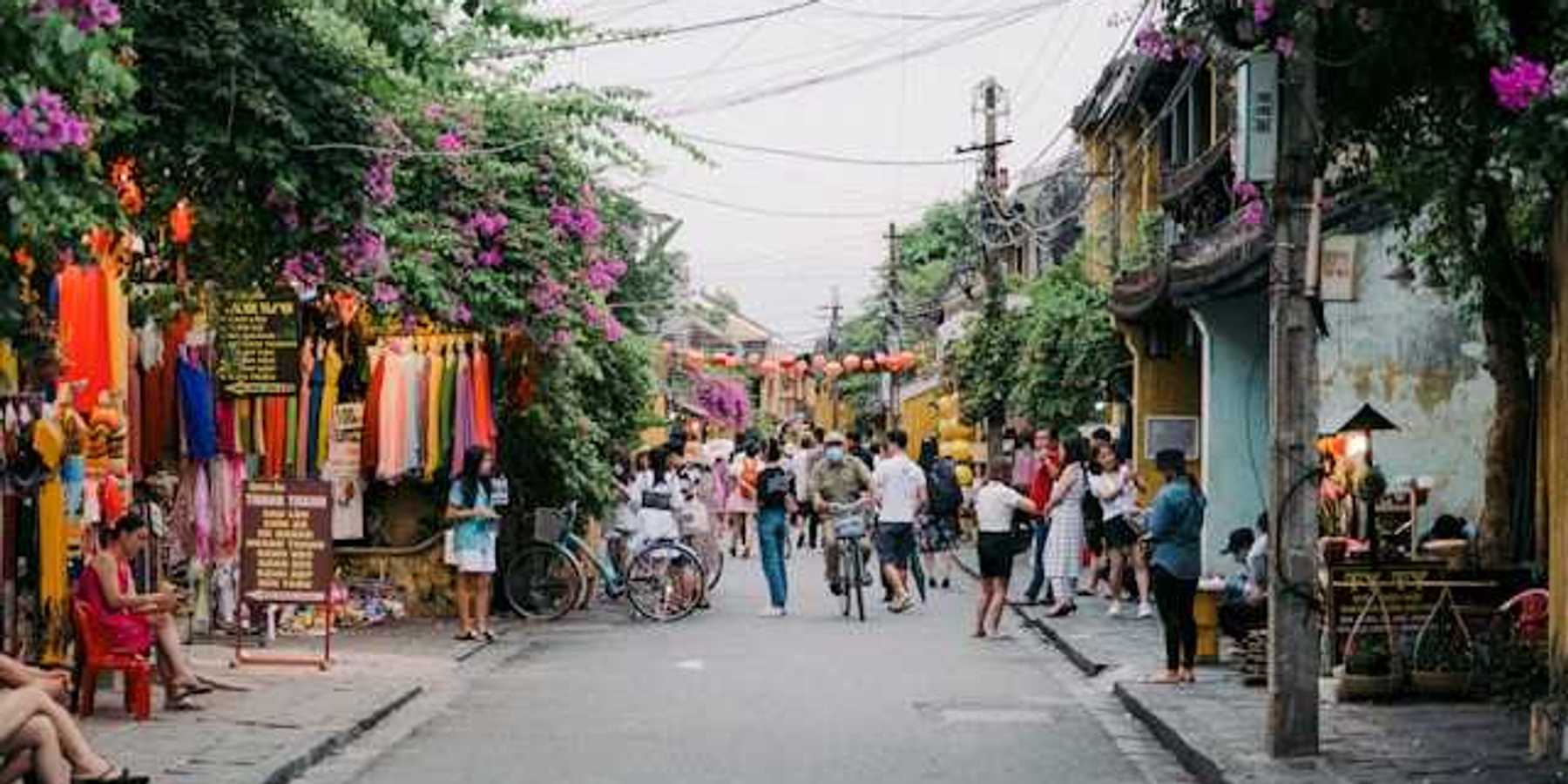 A view of a street with lots of flowering vines growing on the houses