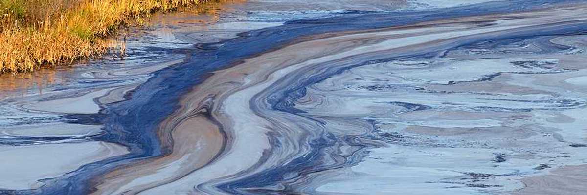 A view of a water source with oil slick on the top