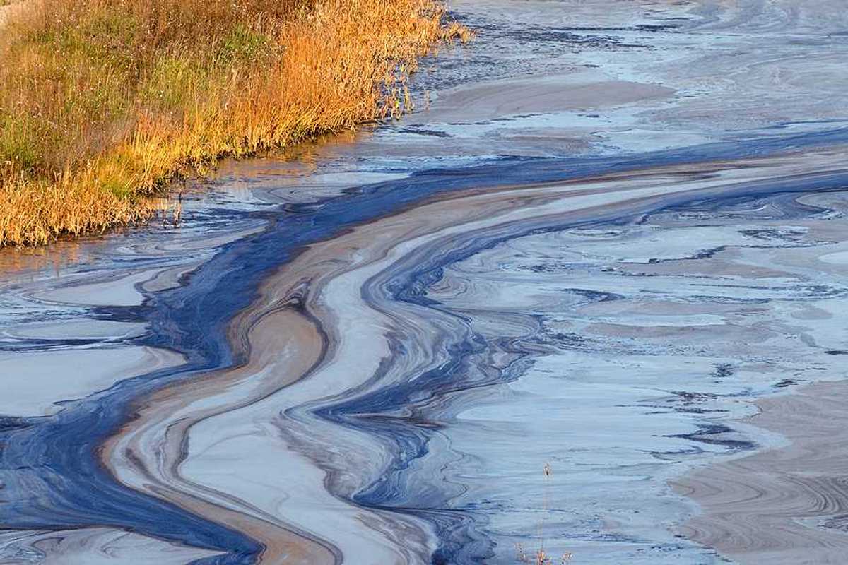 A view of a water source with oil slick on the top