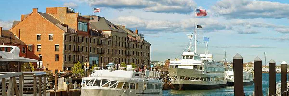 A view of Boston Harbor with ferries nearing a dock