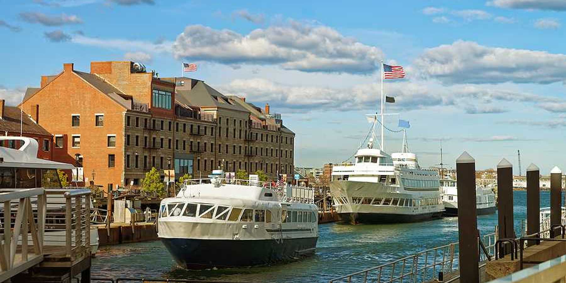 A view of Boston Harbor with ferries nearing a dock