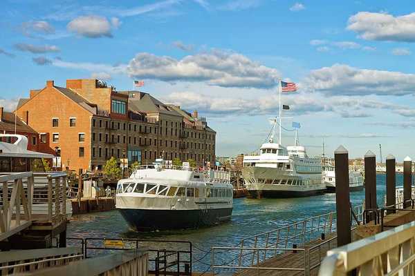 A view of Boston Harbor with ferries nearing a dock