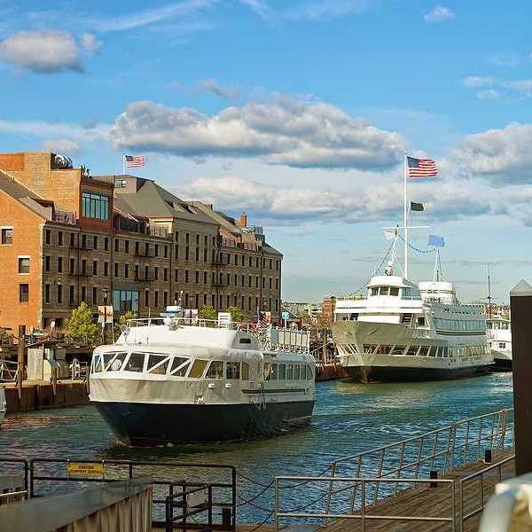 A view of Boston Harbor with ferries nearing a dock
