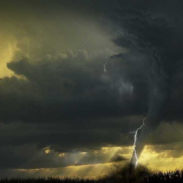 A view of dark storm clouds with lightning and a tornado forming