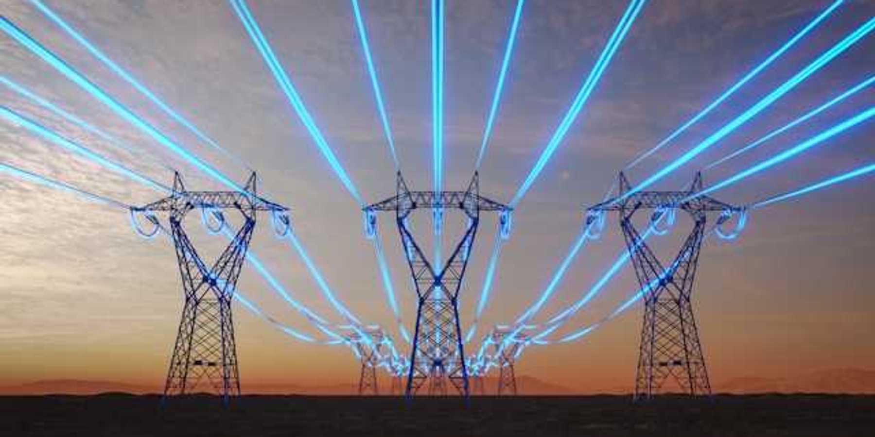 A view of electricity towers with blue wires stretching into the distance against a red sky during sunset
