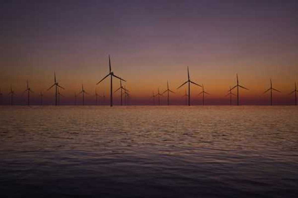 A view of offshore wind turbines with the sunset in the background