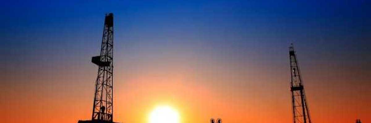 A view of oil pumps and flaring towers at sunset