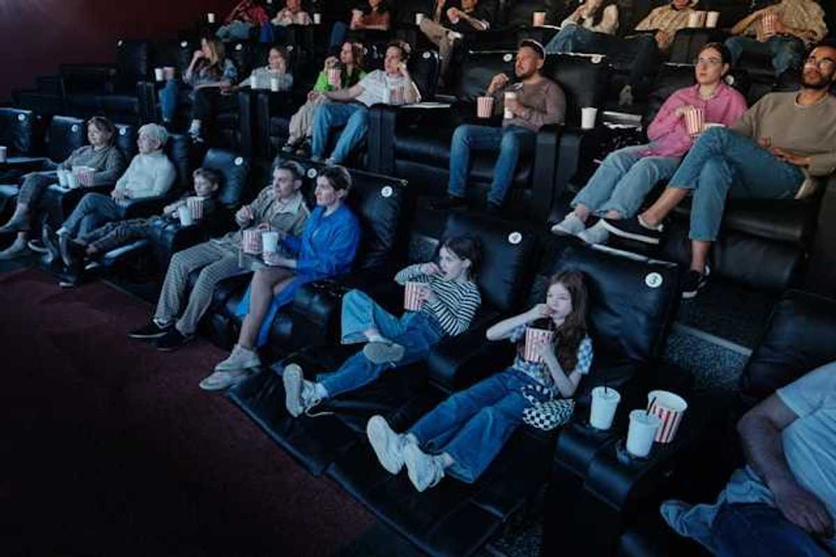 A view of people sitting in a movie theater watching a movie