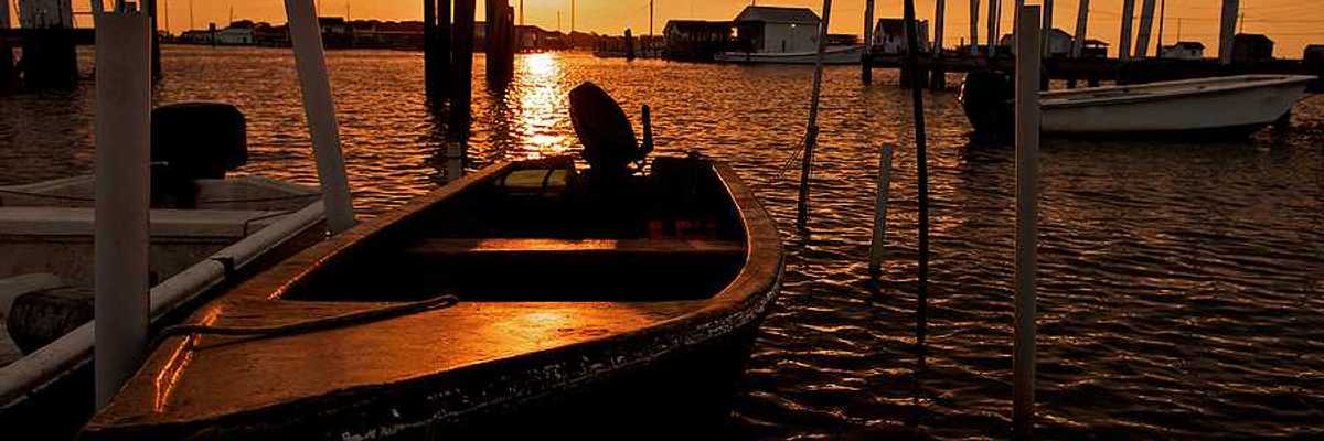 A view of small motorboats at a dock at sunset