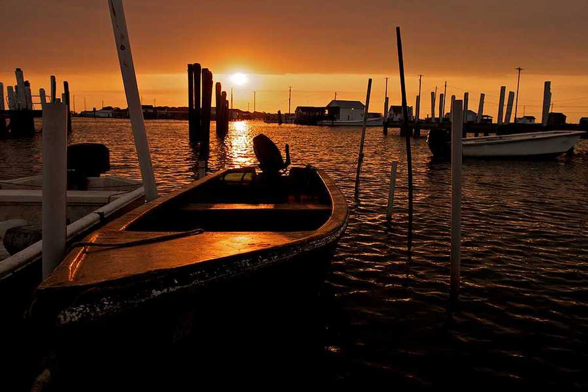 A view of small motorboats at a dock at sunset