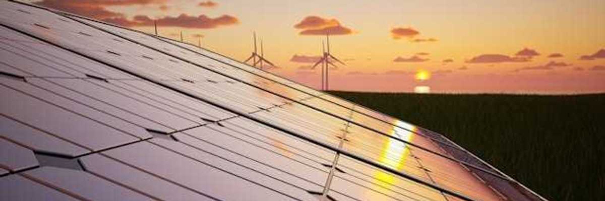 A view of solar panels and wind turbines in the background