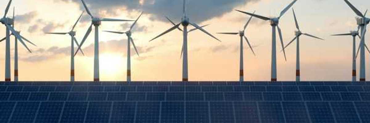 A view of solar panels with wind turbines in the background
