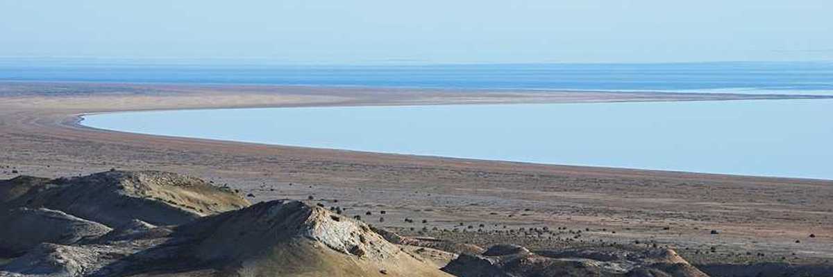 A view of the Aral Sea in Uzbekistan showing the water receding from a dry environment