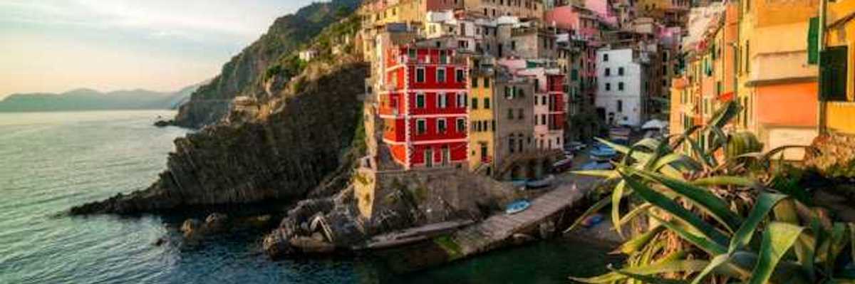 A view of the coastline of Cinque Terre with colorful buildings lining a hillside above the water