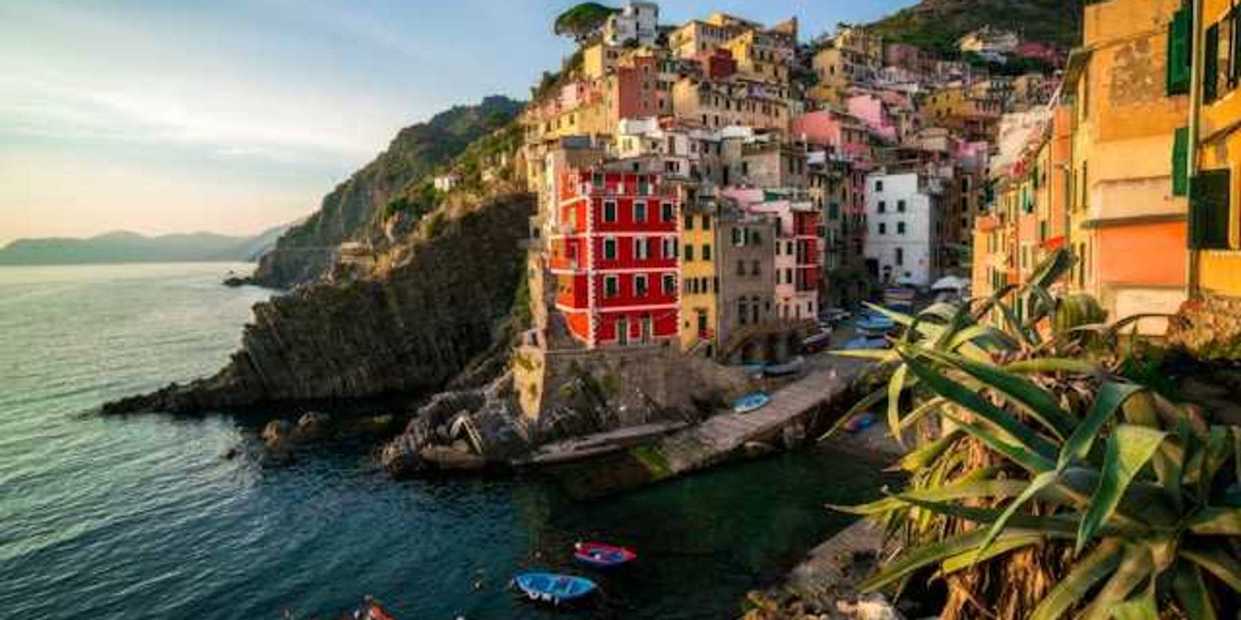 A view of the coastline of Cinque Terre with colorful buildings lining a hillside above the water