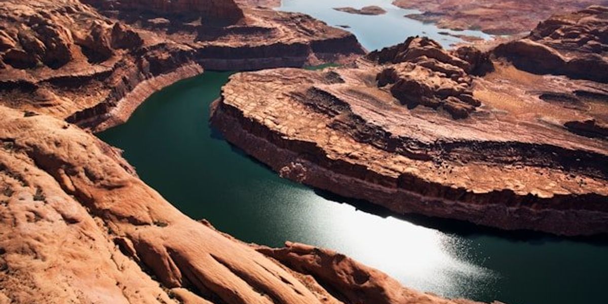 A view of the Colorado River winding through a dry rocky landscape.