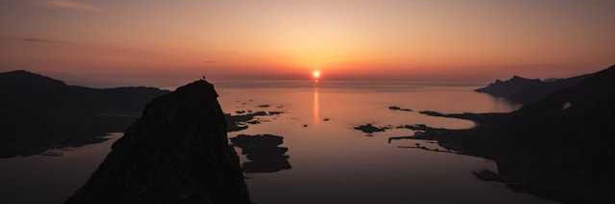 A view of the ocean with a sunset in the background