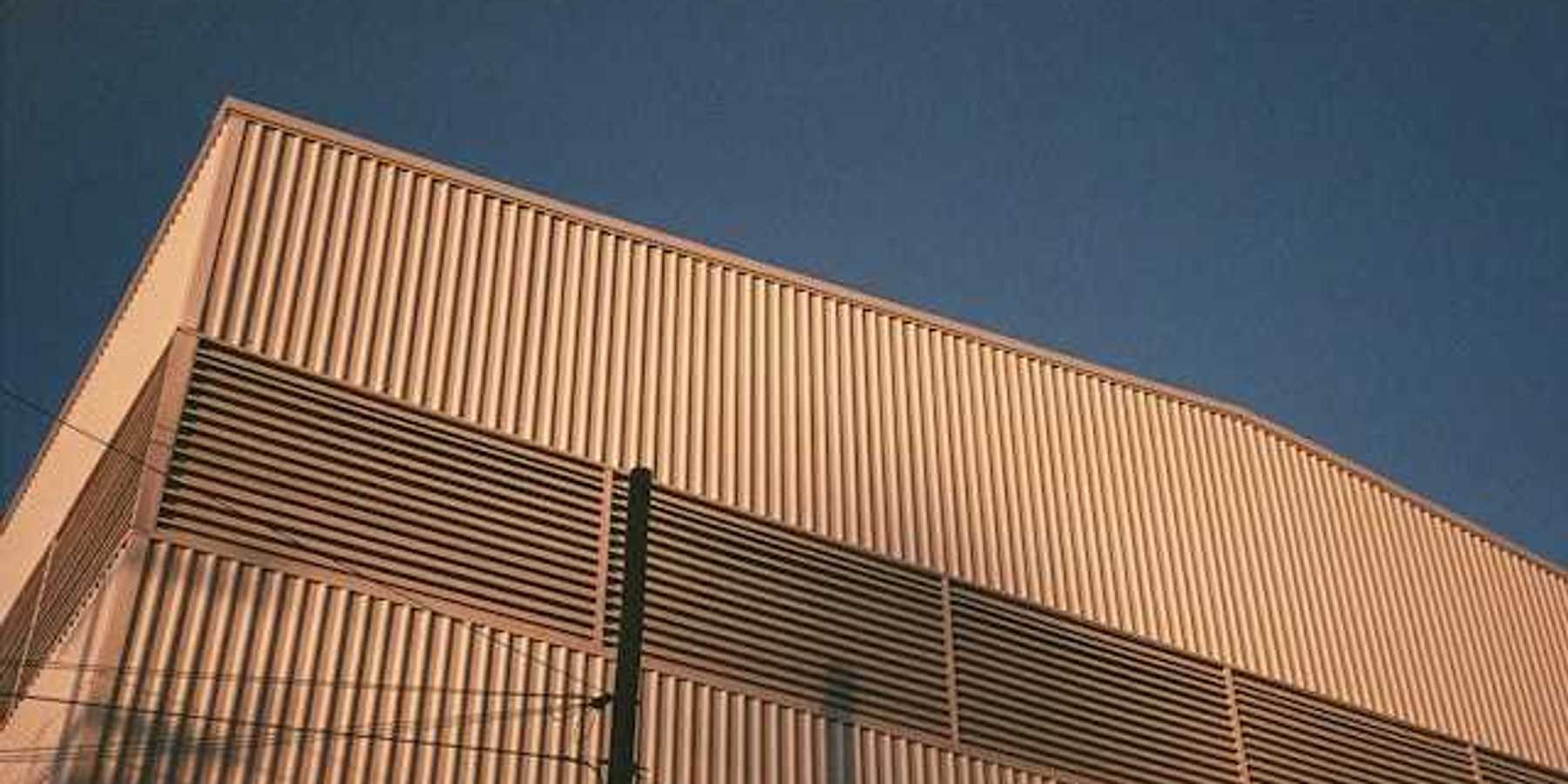 A view of the side of a warehouse building with the blue sky in the background