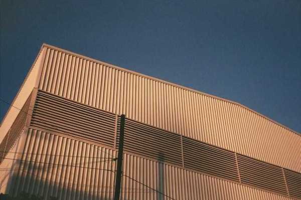 A view of the side of a warehouse building with the blue sky in the background