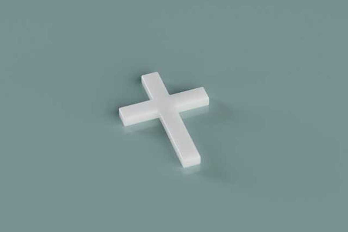 A white cross sitting on a green background
