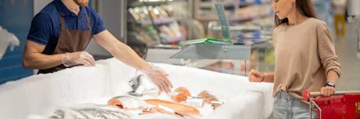 A woman at the fish market talking to a fish monger