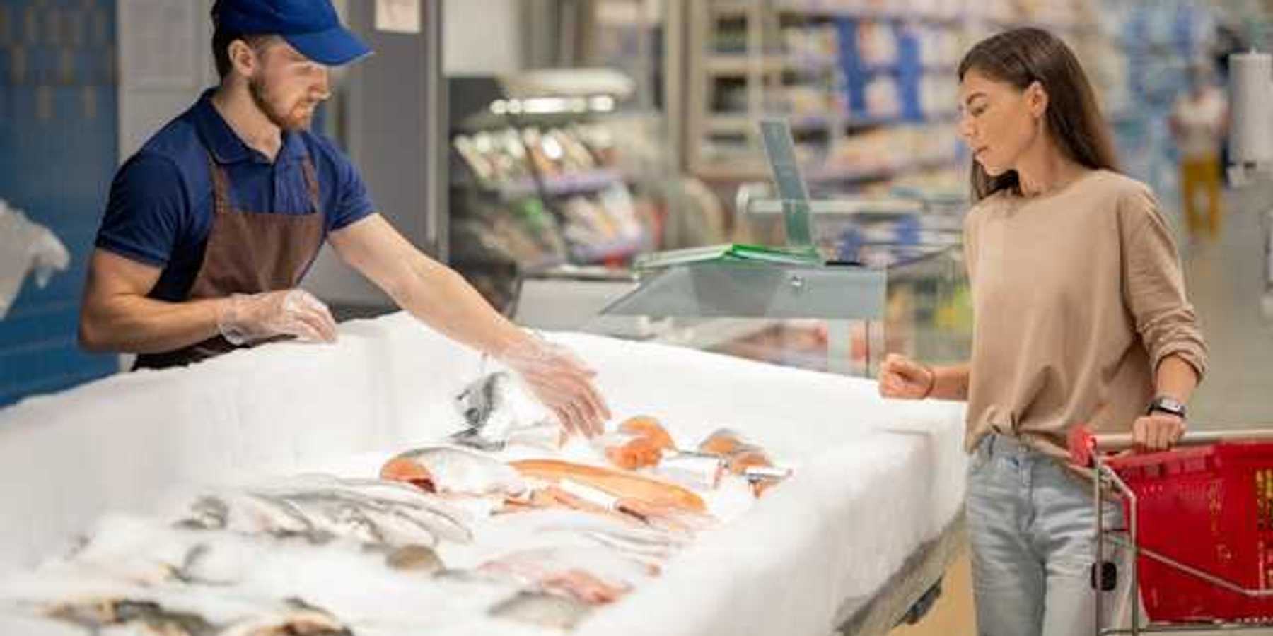 A woman at the fish market talking to a fish monger