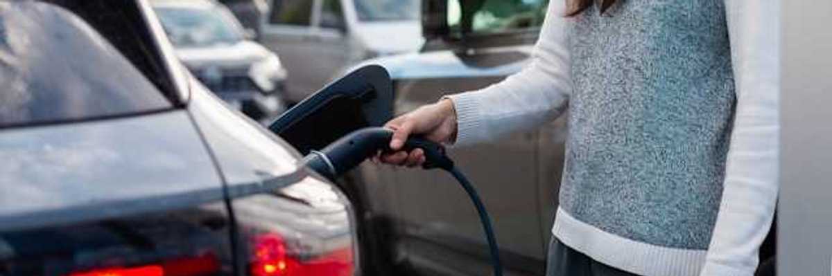 A woman charging an electric vehicle