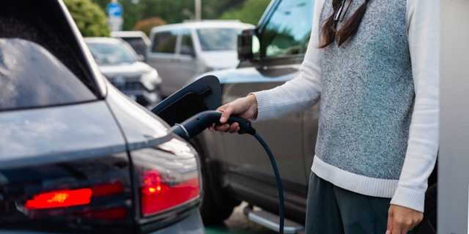 A woman charging an electric vehicle