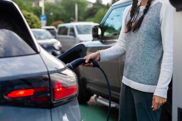A woman charging an electric vehicle