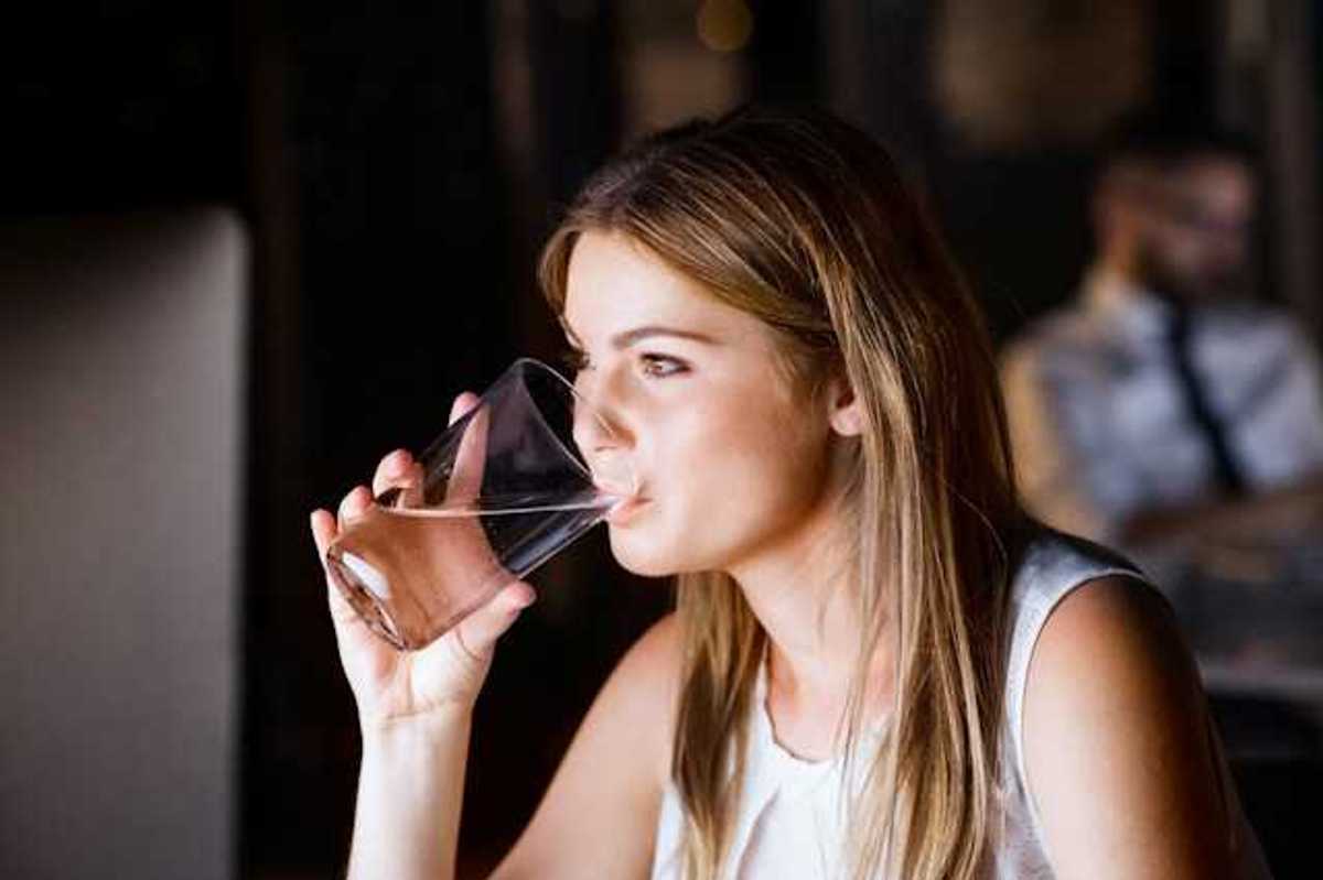 A woman drinking water out of a glass