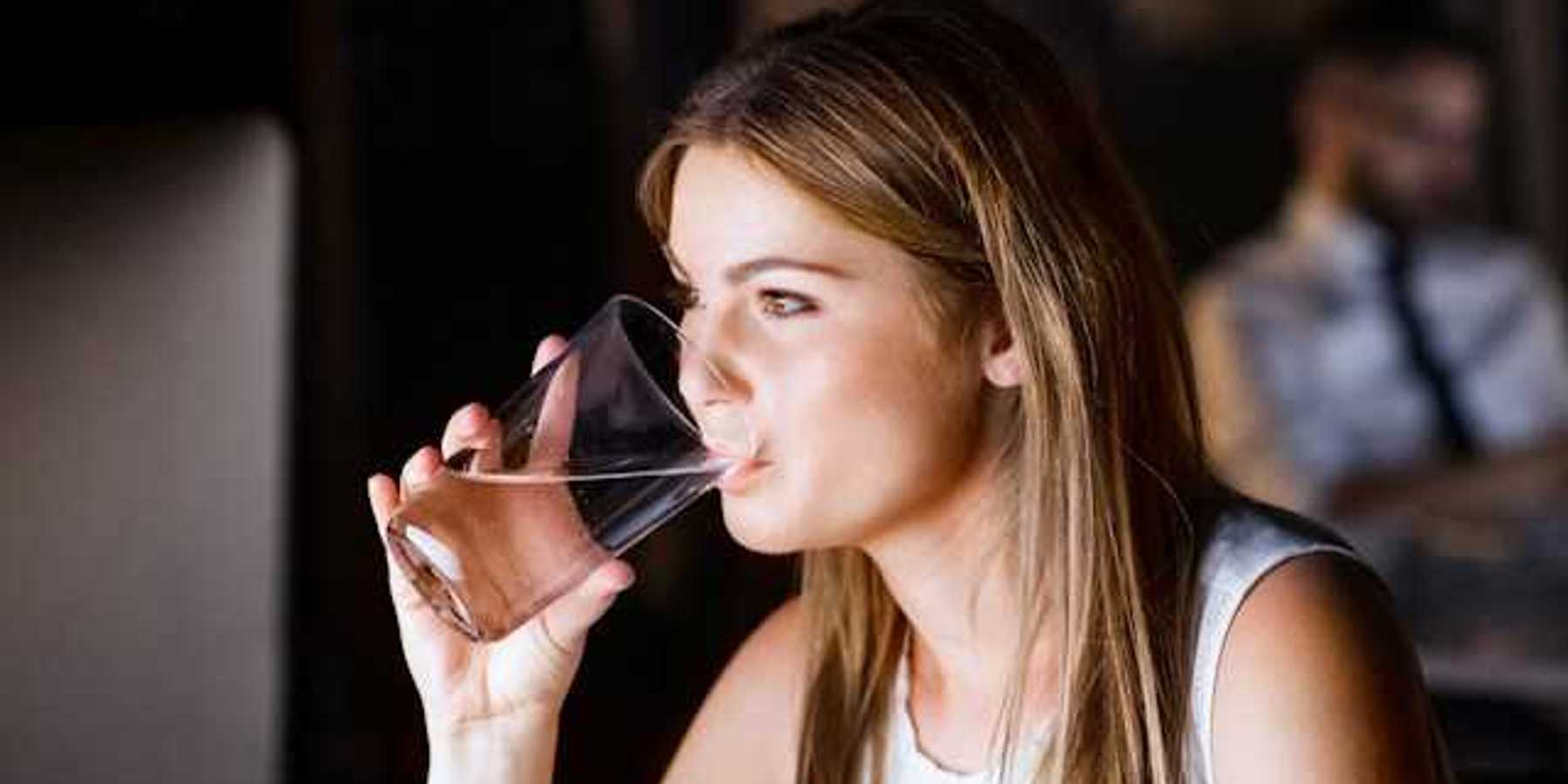 A woman drinking water out of a glass