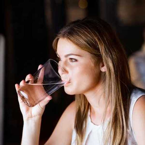 A woman drinking water out of a glass