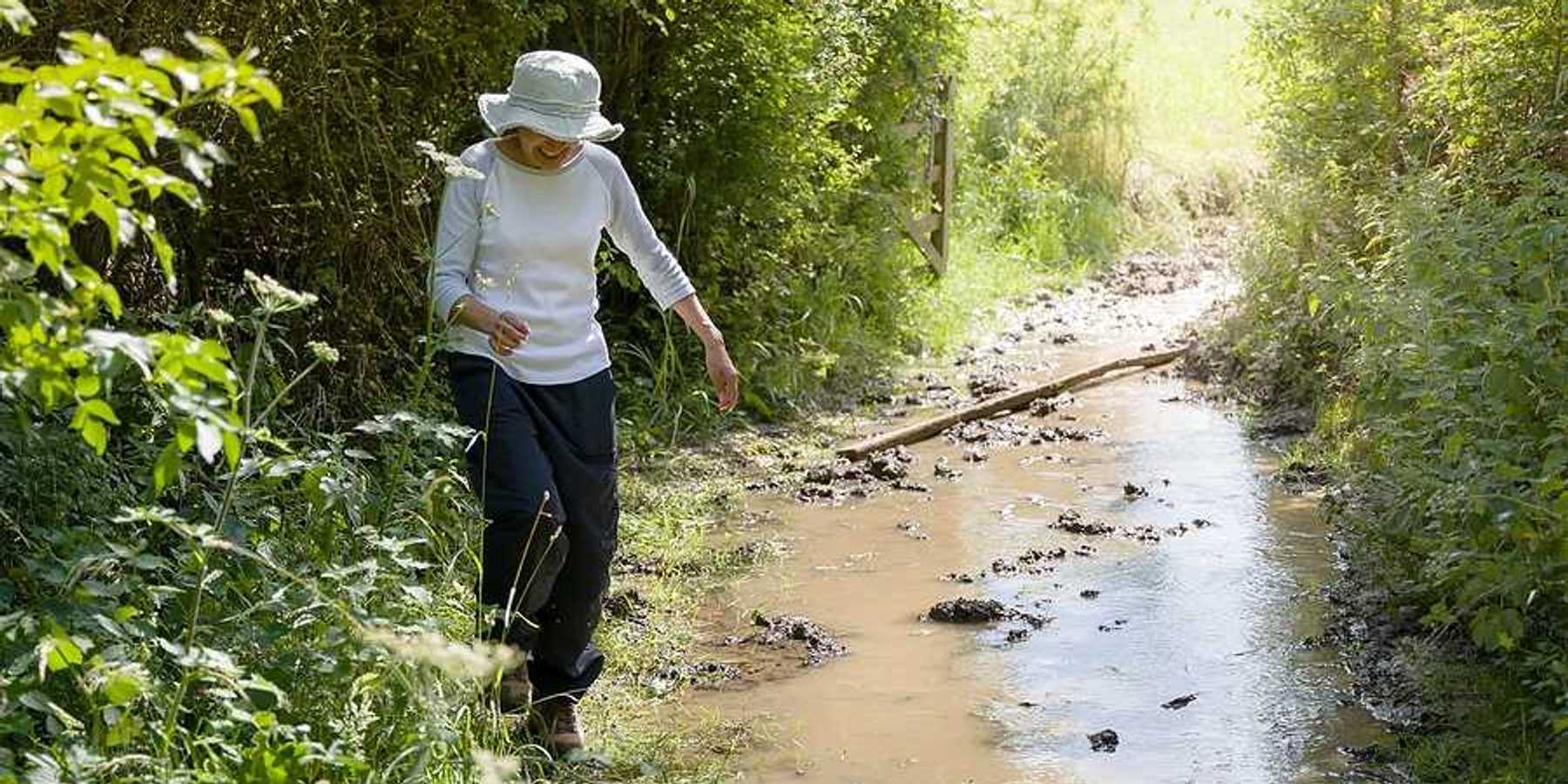 A woman hiking along a flooding stream