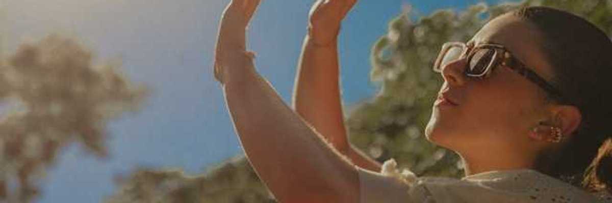 A woman shielding her face from the sun