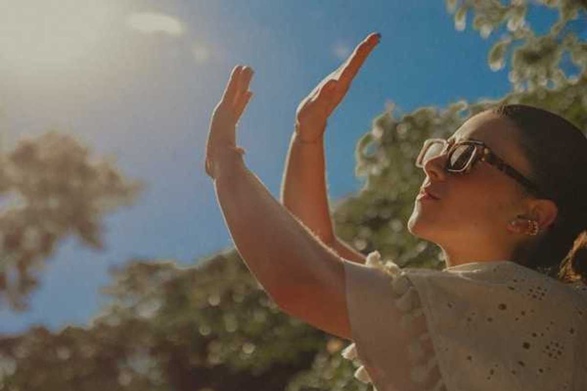 A woman shielding her face from the sun