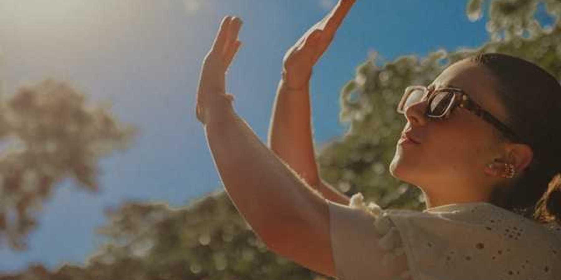 A woman shielding her face from the sun