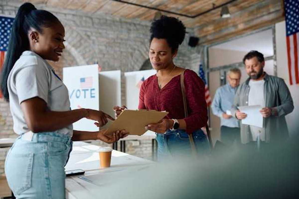A woman talking to a voting representative at a polling station