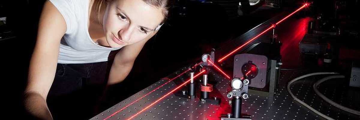 A woman working with a laser in a lab