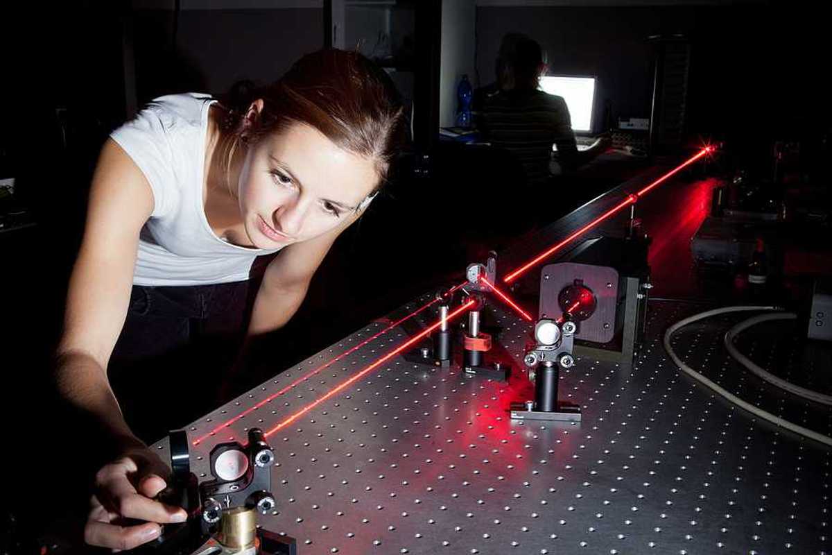 A woman working with a laser in a lab
