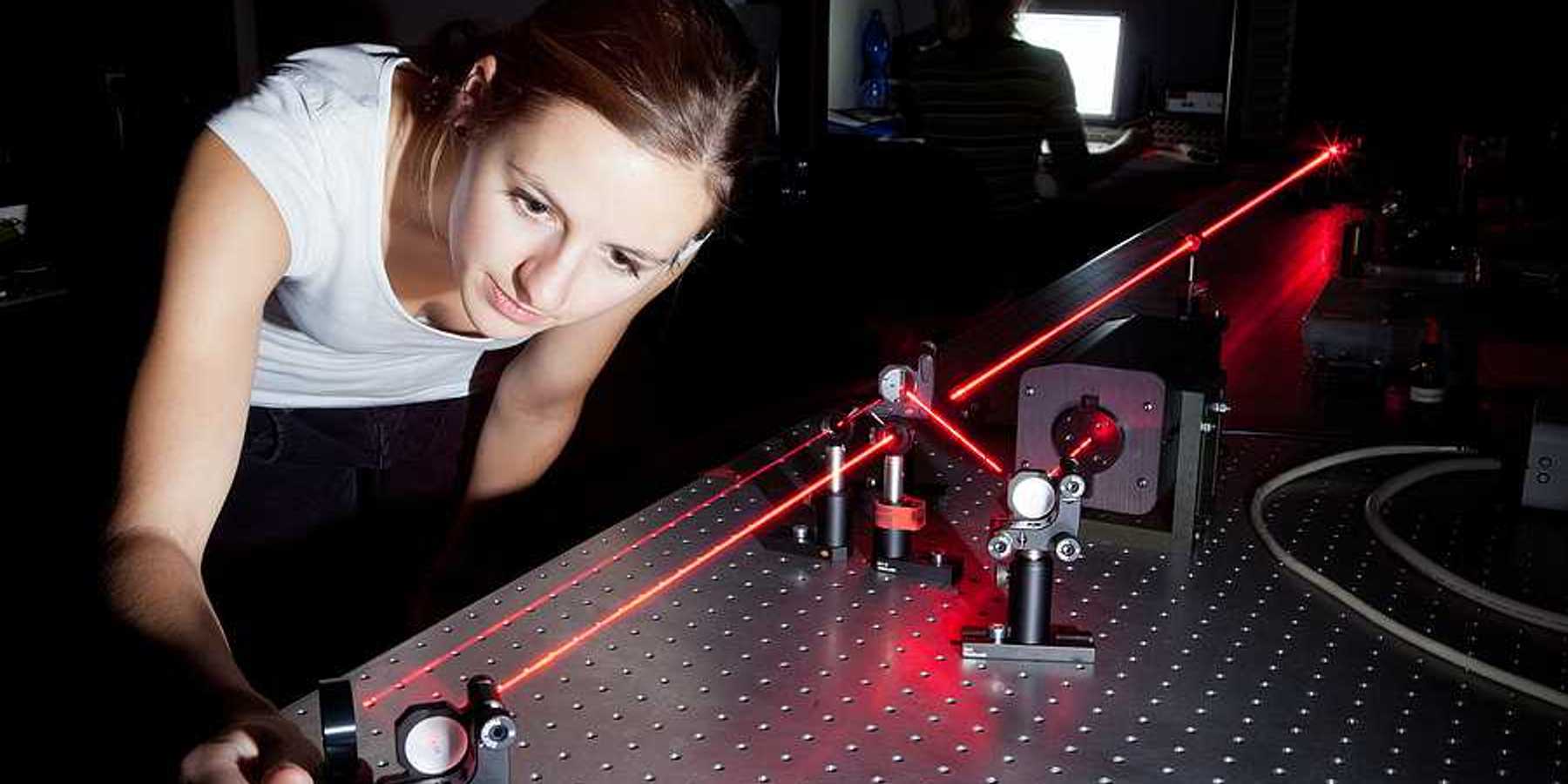 A woman working with a laser in a lab