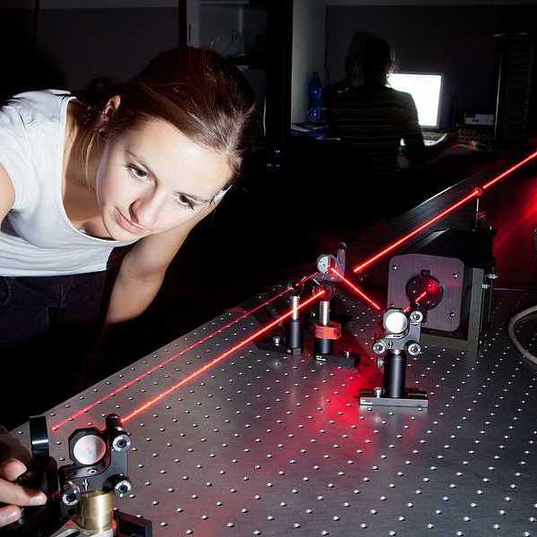 A woman working with a laser in a lab